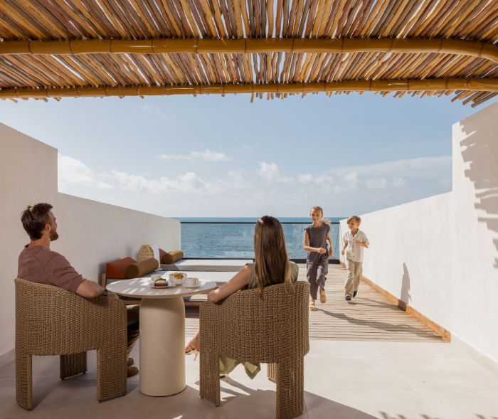 a family sitting at a table on a deck