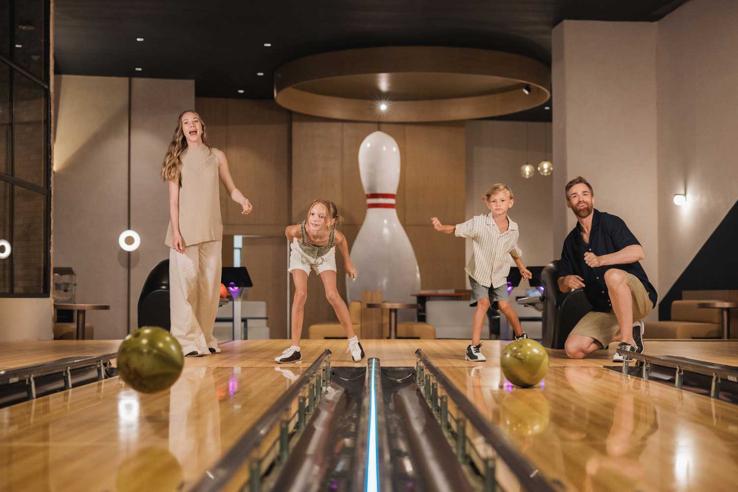 a group of people standing on a bowling alley