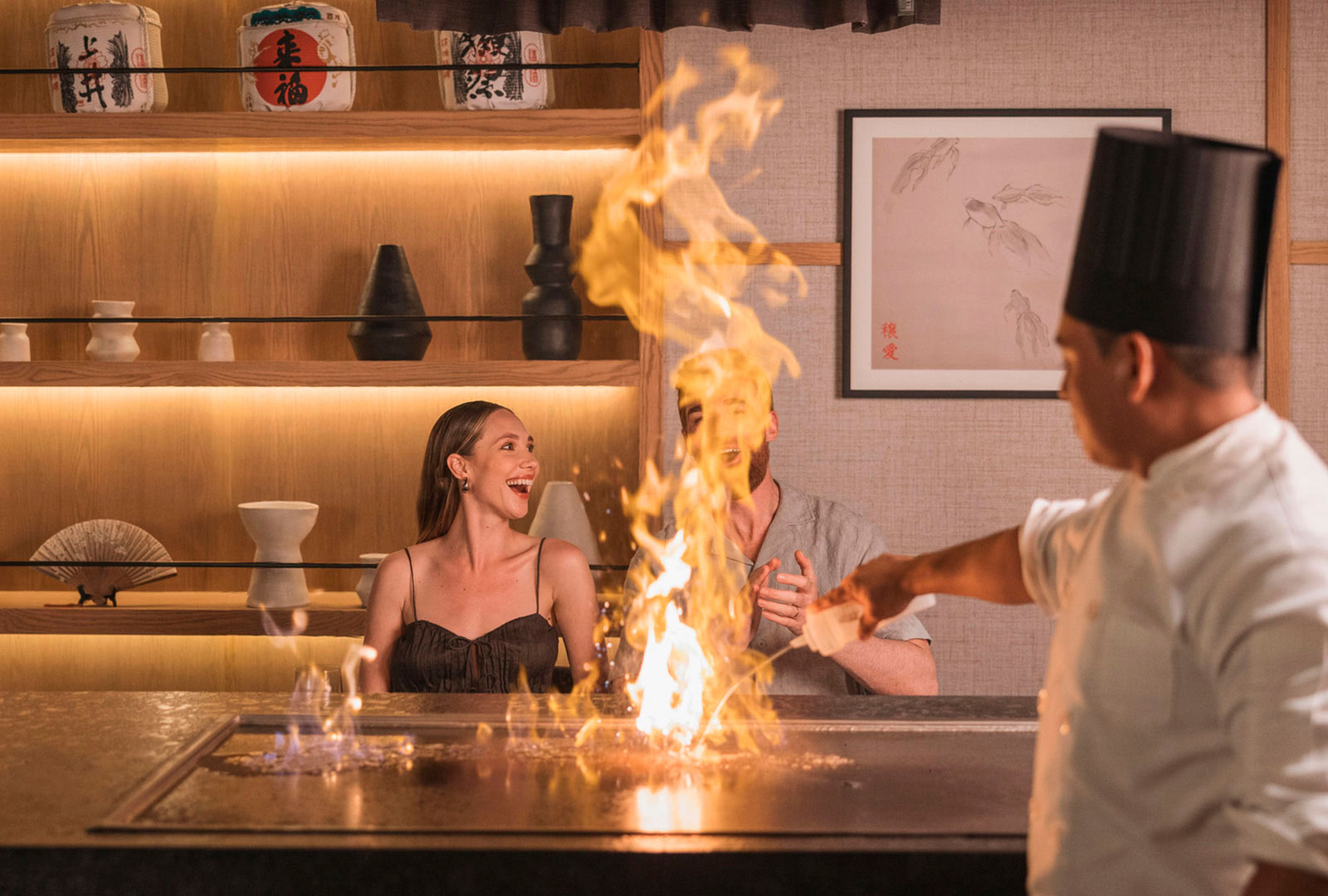 a man pouring a liquid into a fire