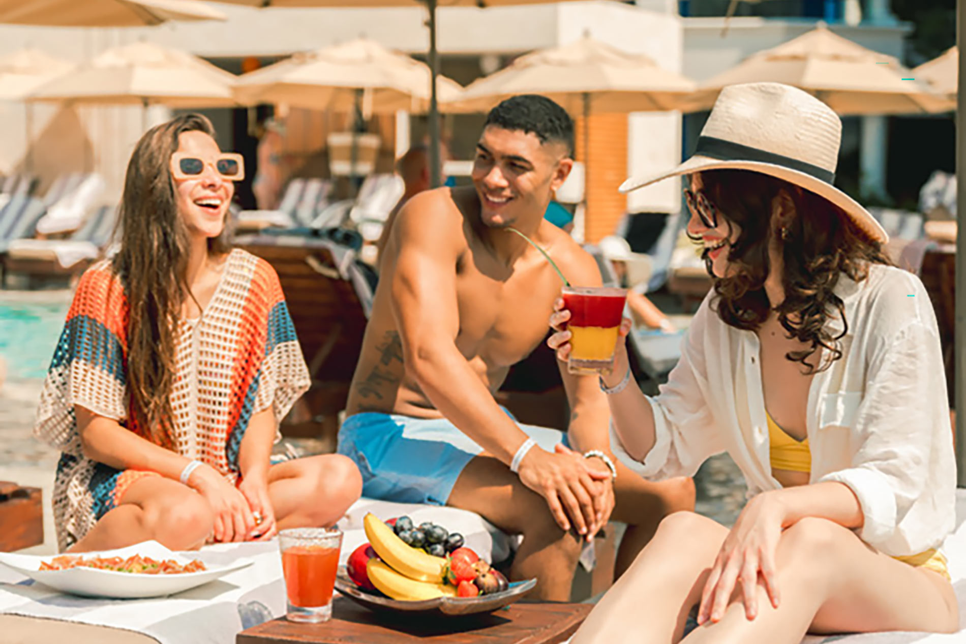 a group of people sitting on a lounge chair by a pool