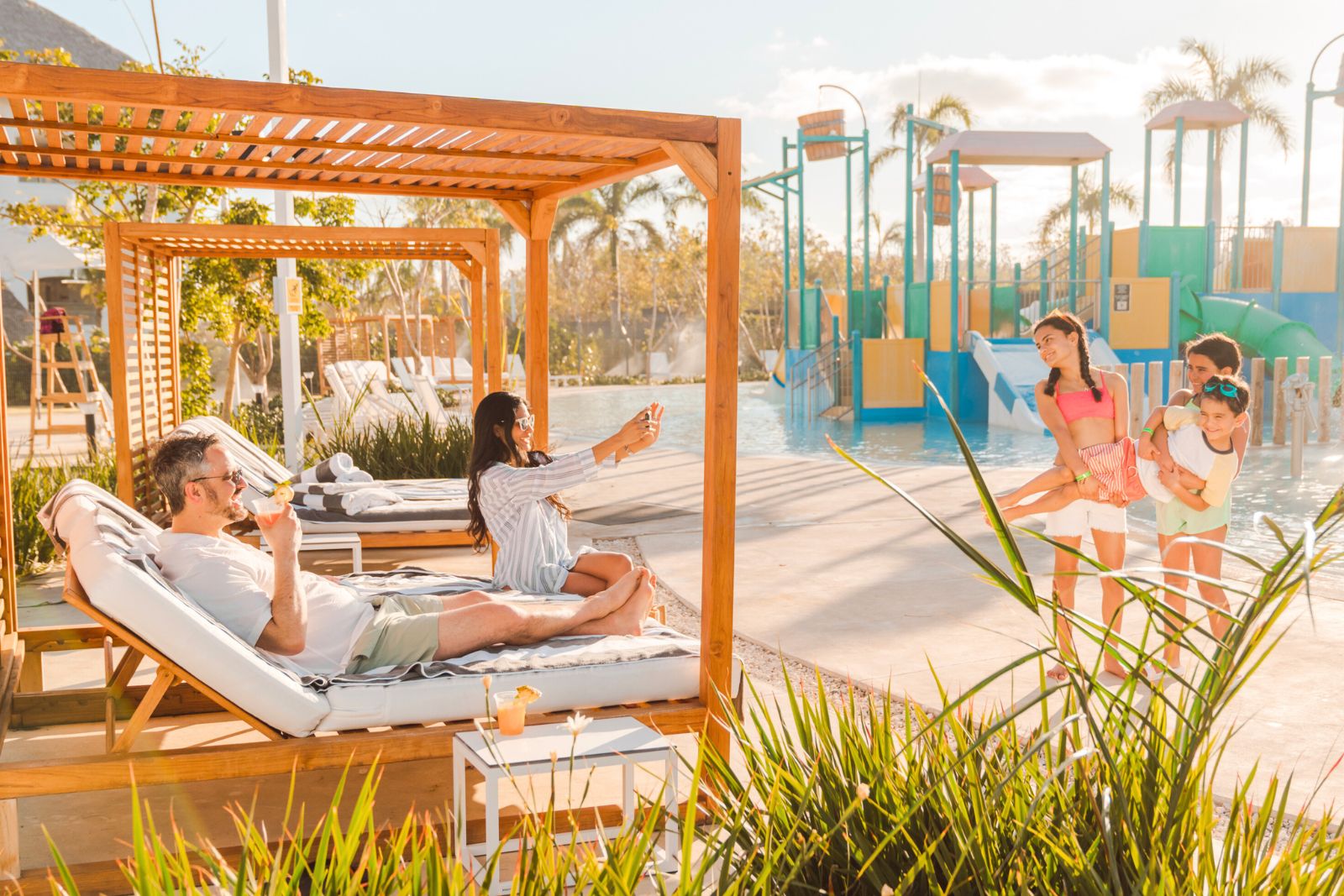 a group of people sitting on lounge chairs by a pool