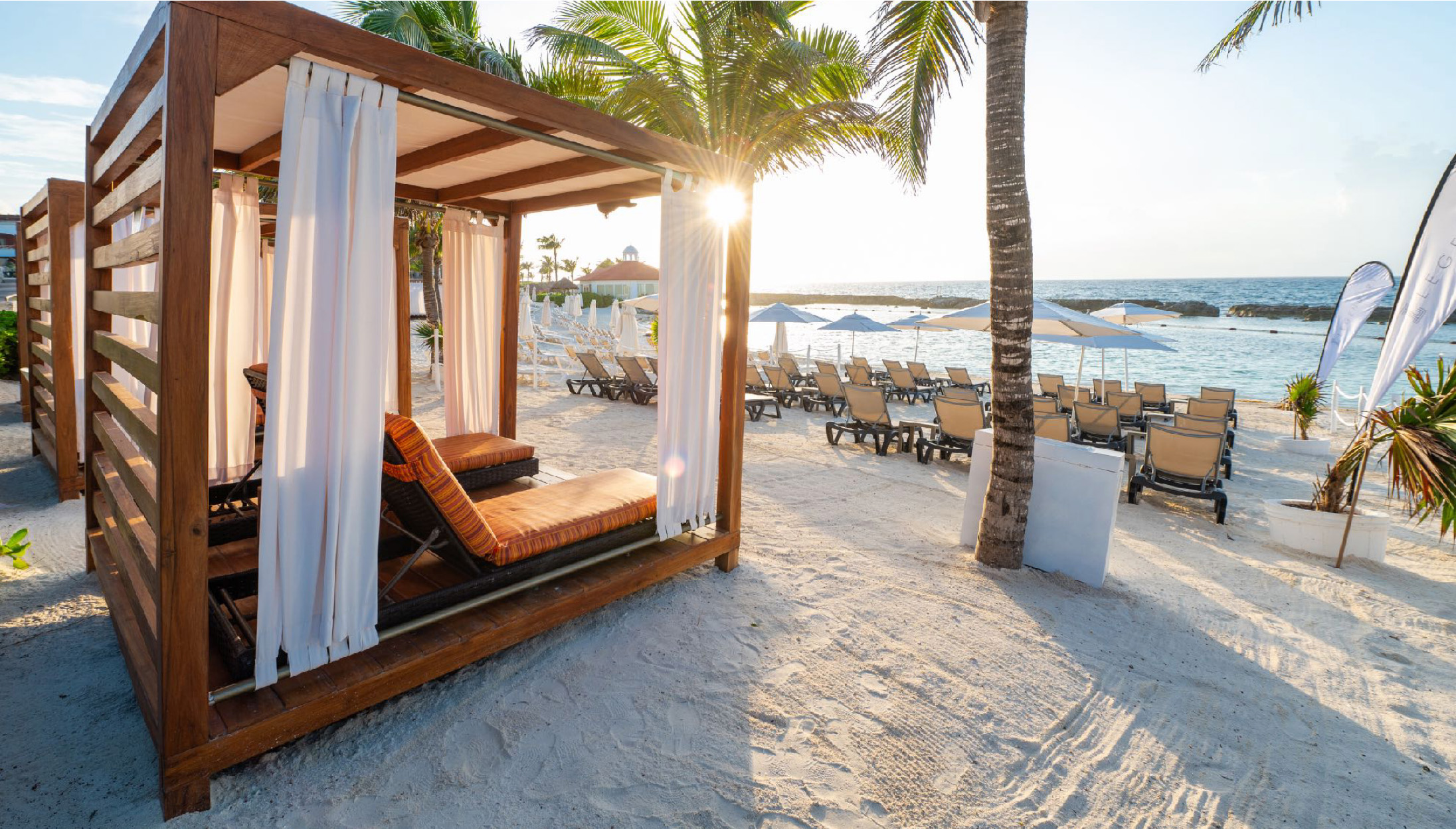 a beach with a canopy and palm trees