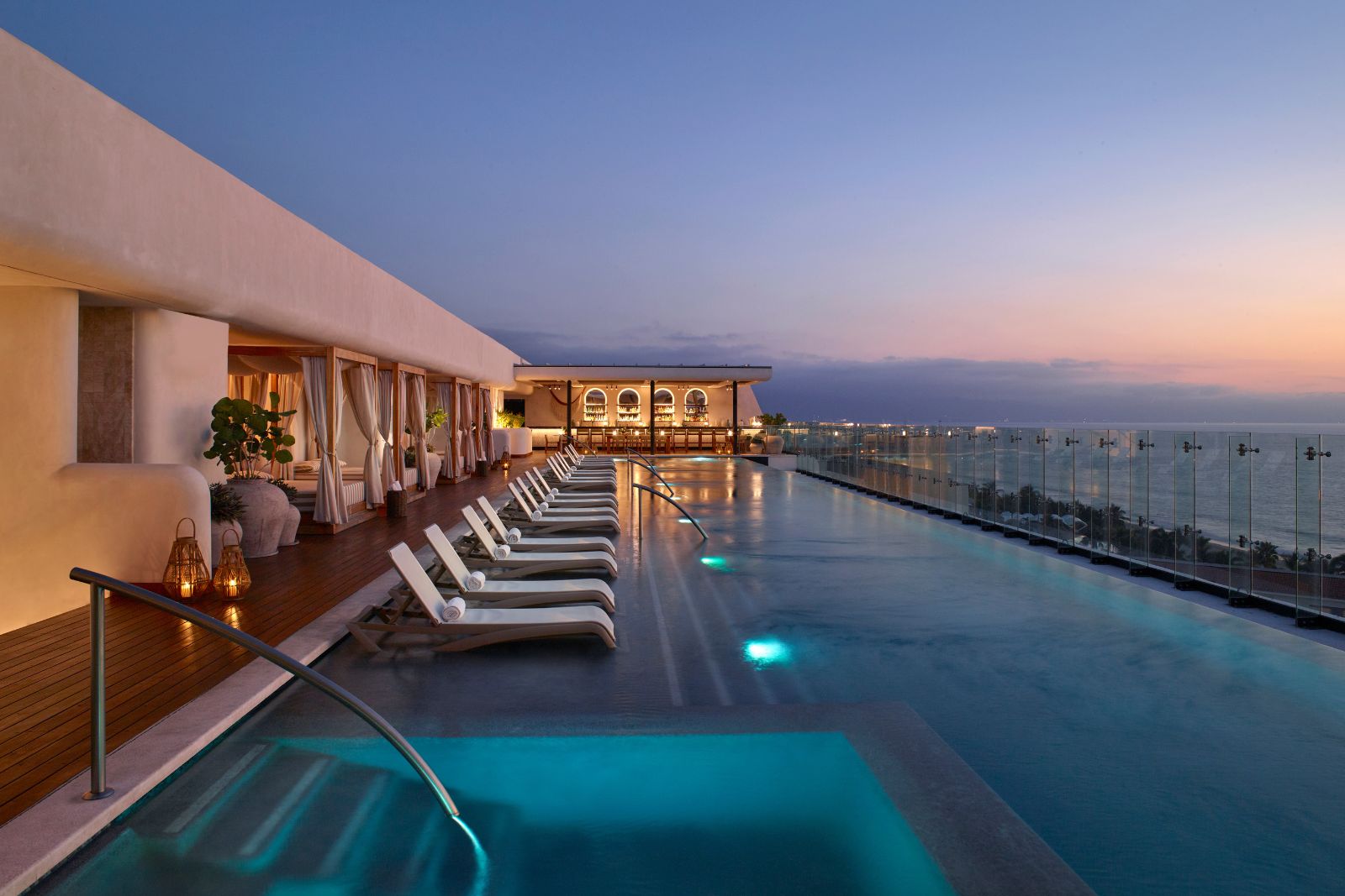 a pool with chairs and a building with a body of water