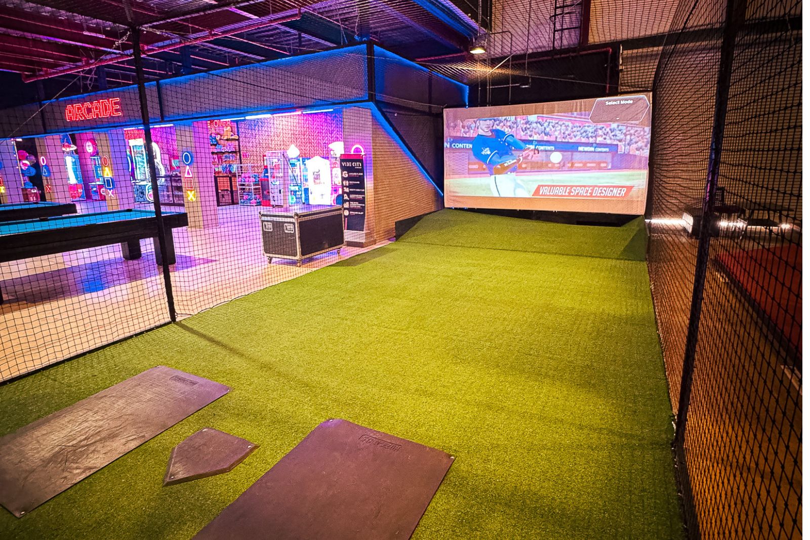 a golf course with a screen and a baseball bat