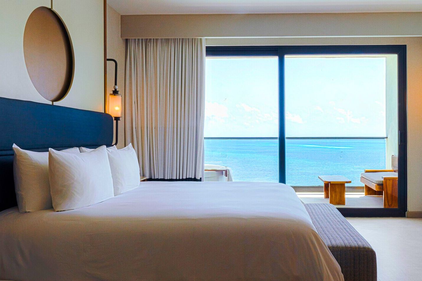 uma cama com uma grande janela com vista para o oceano